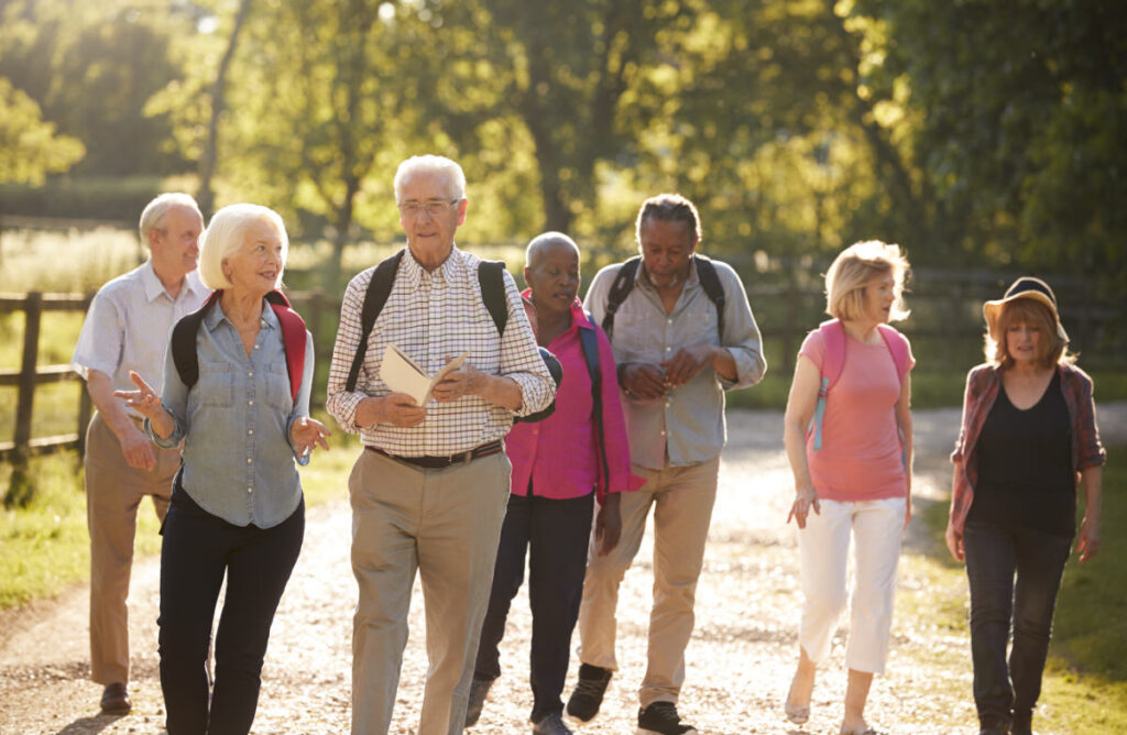 Group of Senior Friends in walking group independent retirement community walking on gravel path